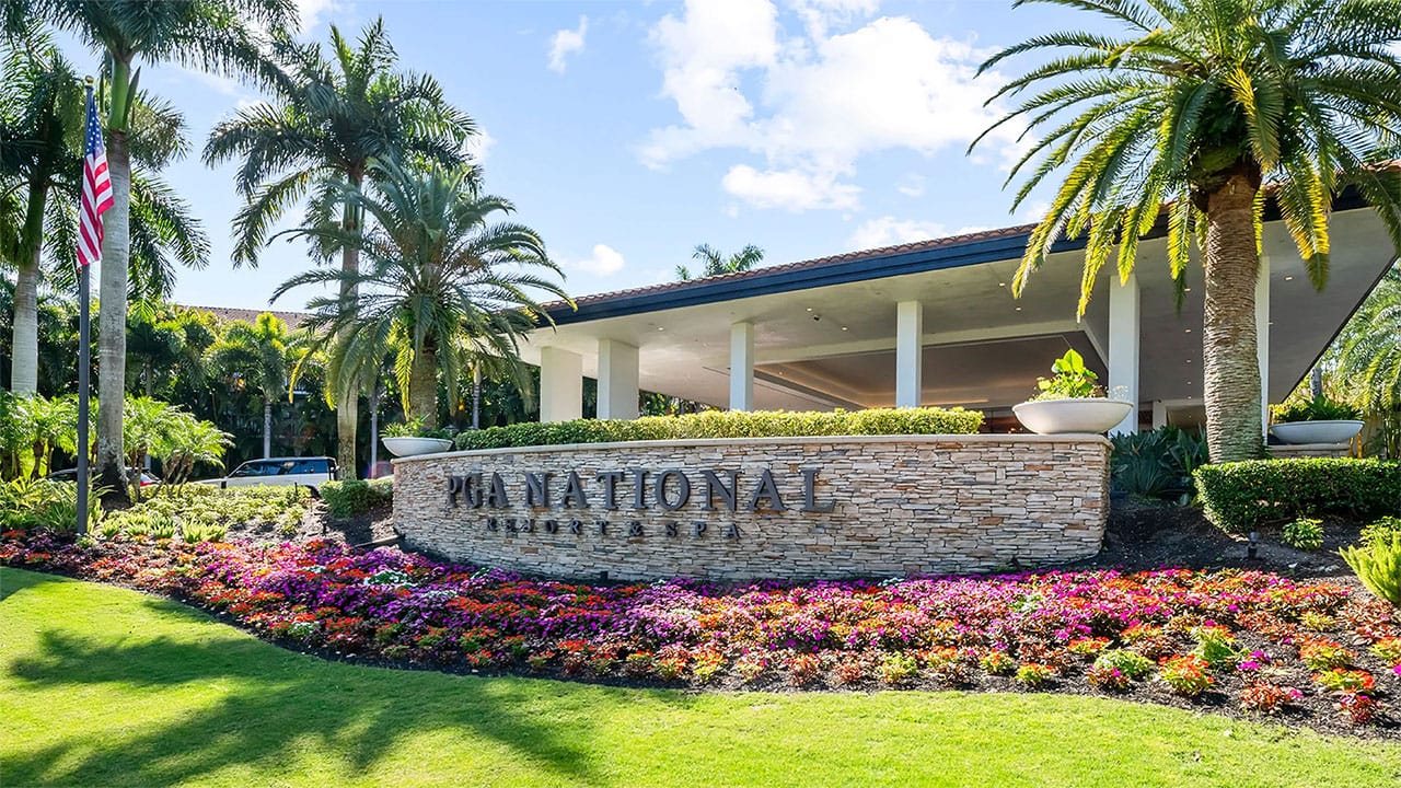 PGA National entrance with sign and palm trees