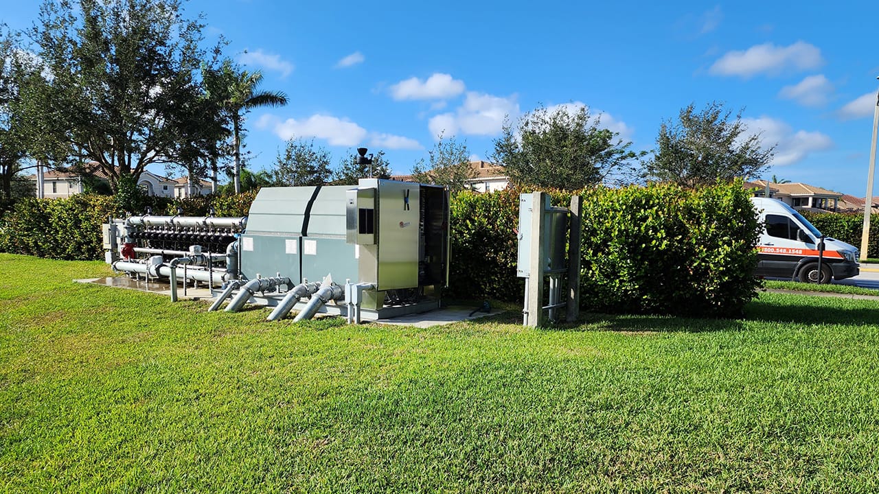 Riverstone pump station installed against some hedges