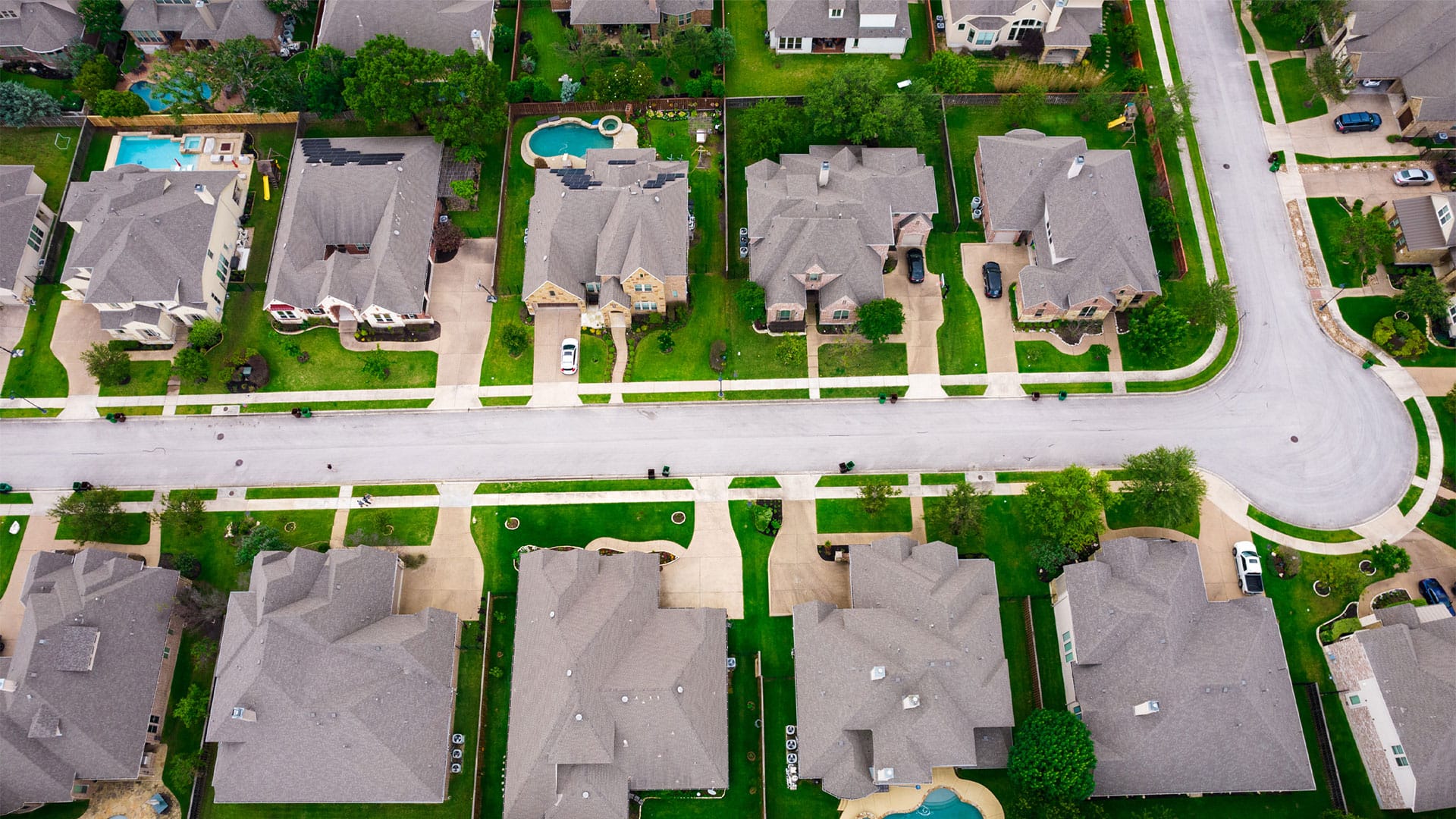 Drone view of a gated community with gardens and pools