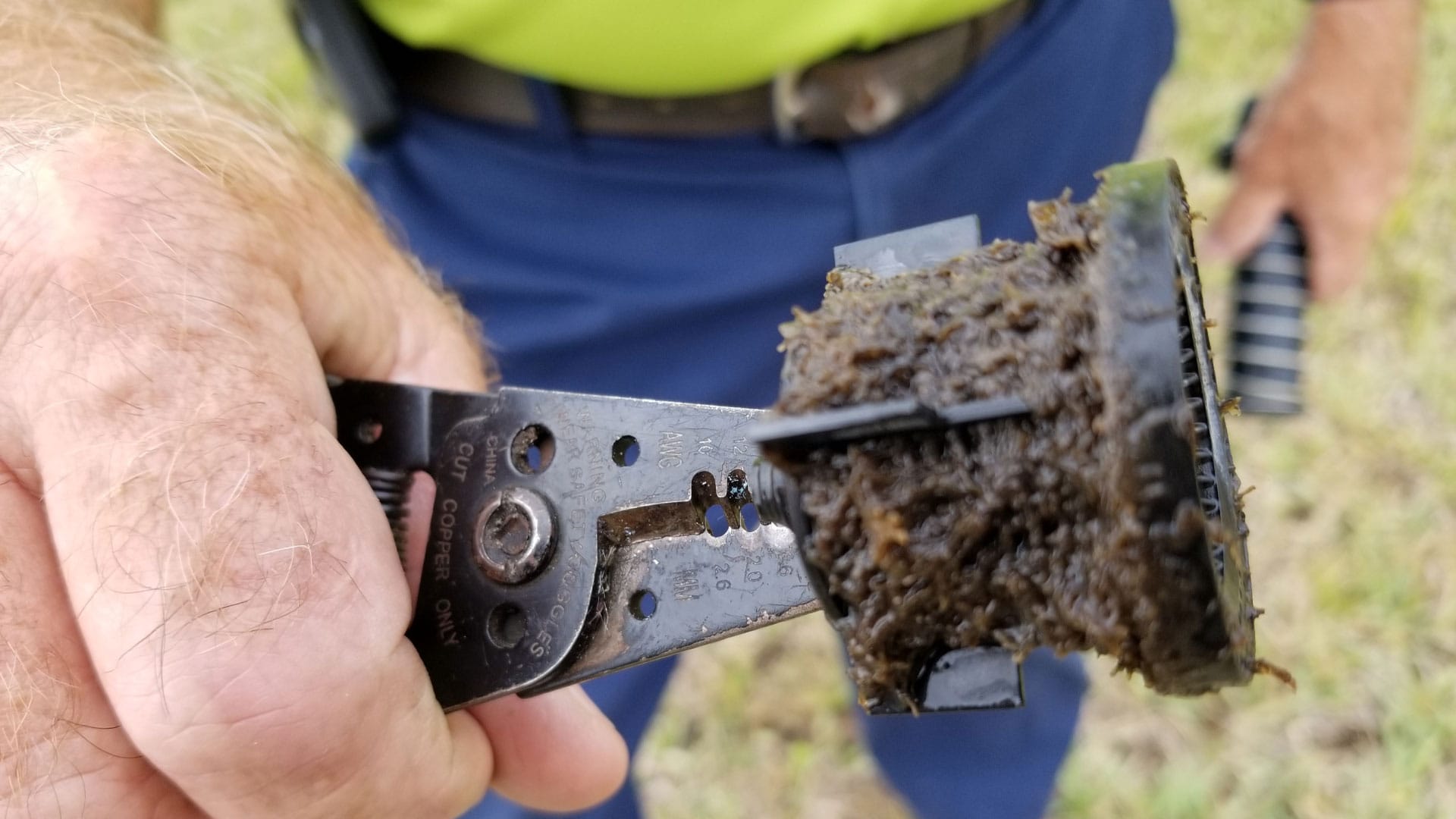Close up of a man holding a clogged pump filter