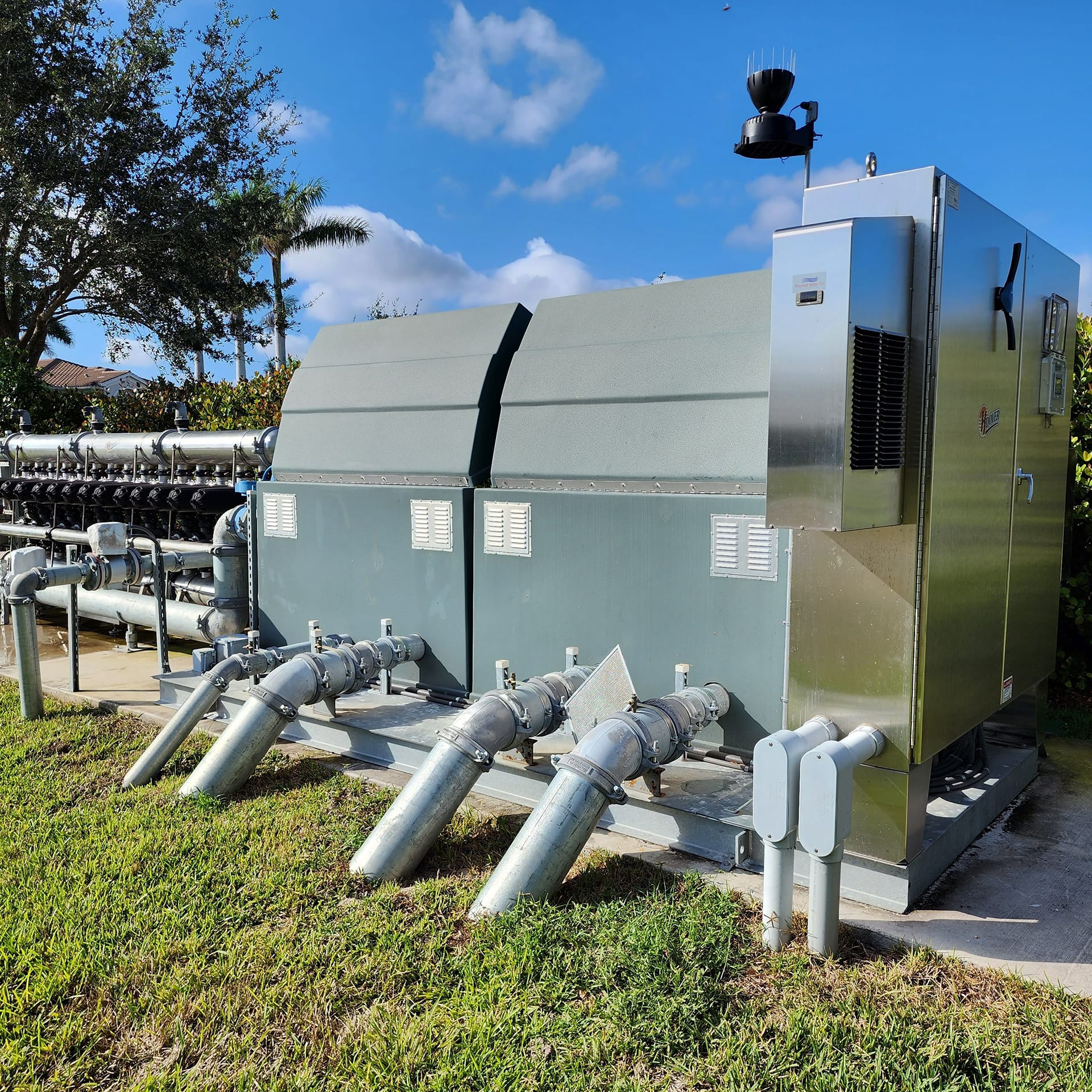 The back end of the Hoover pump station with pipes going into the green grass