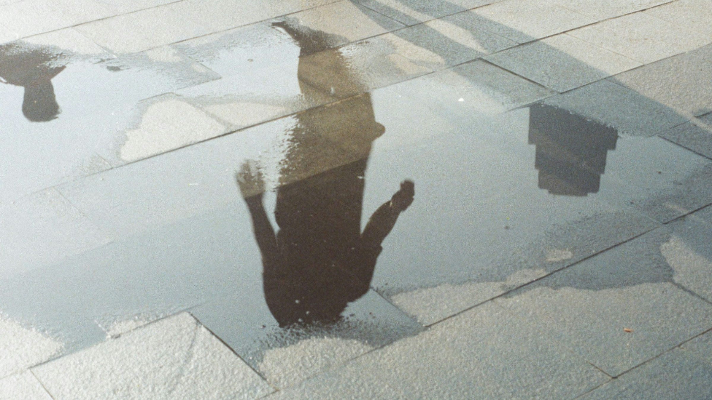 An image of a person about to step into a puddle on a pavement