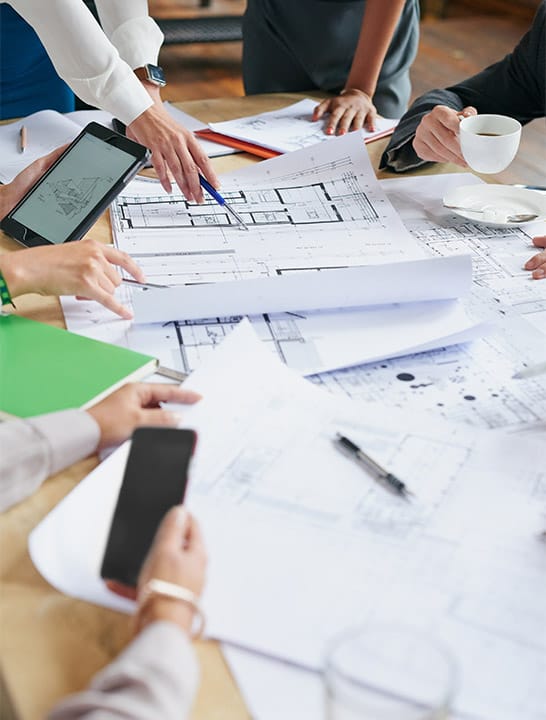 Desk showing building blueprints on papers
